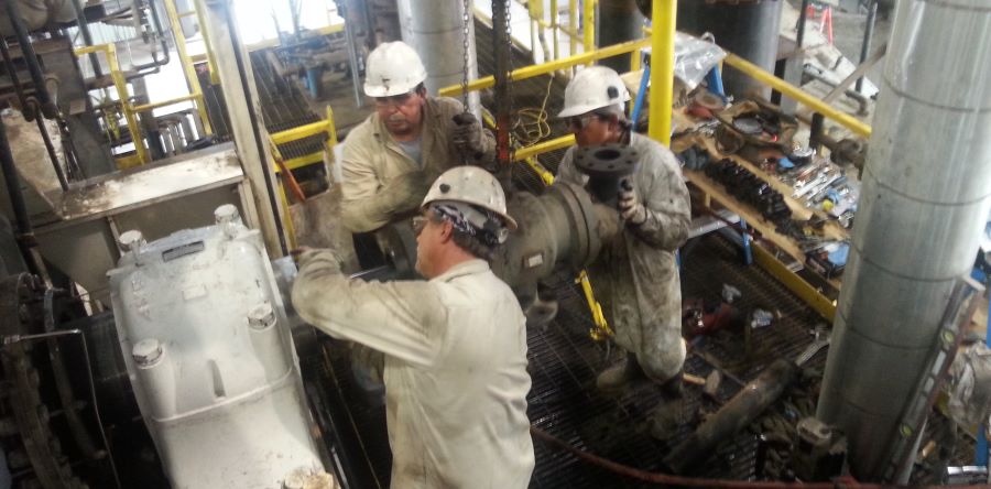 three machanics installing a hot oil rotor thru a C4 roller bearing that was replaced on 14-inch diameter shaft