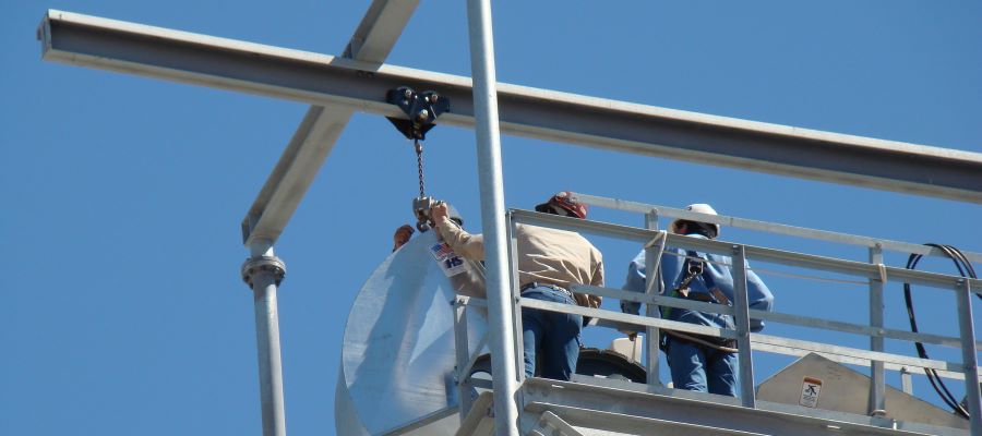 two machanics installing an bucket elevated hood 145ft above ground level